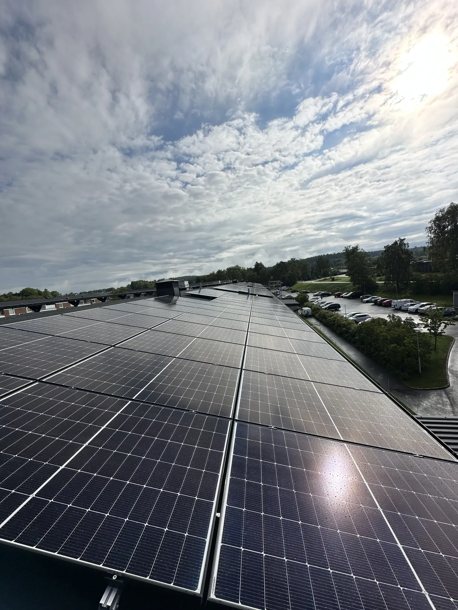 Vidsträckt solcellsanläggning som täcker ett stort platt tak på en fastighet.