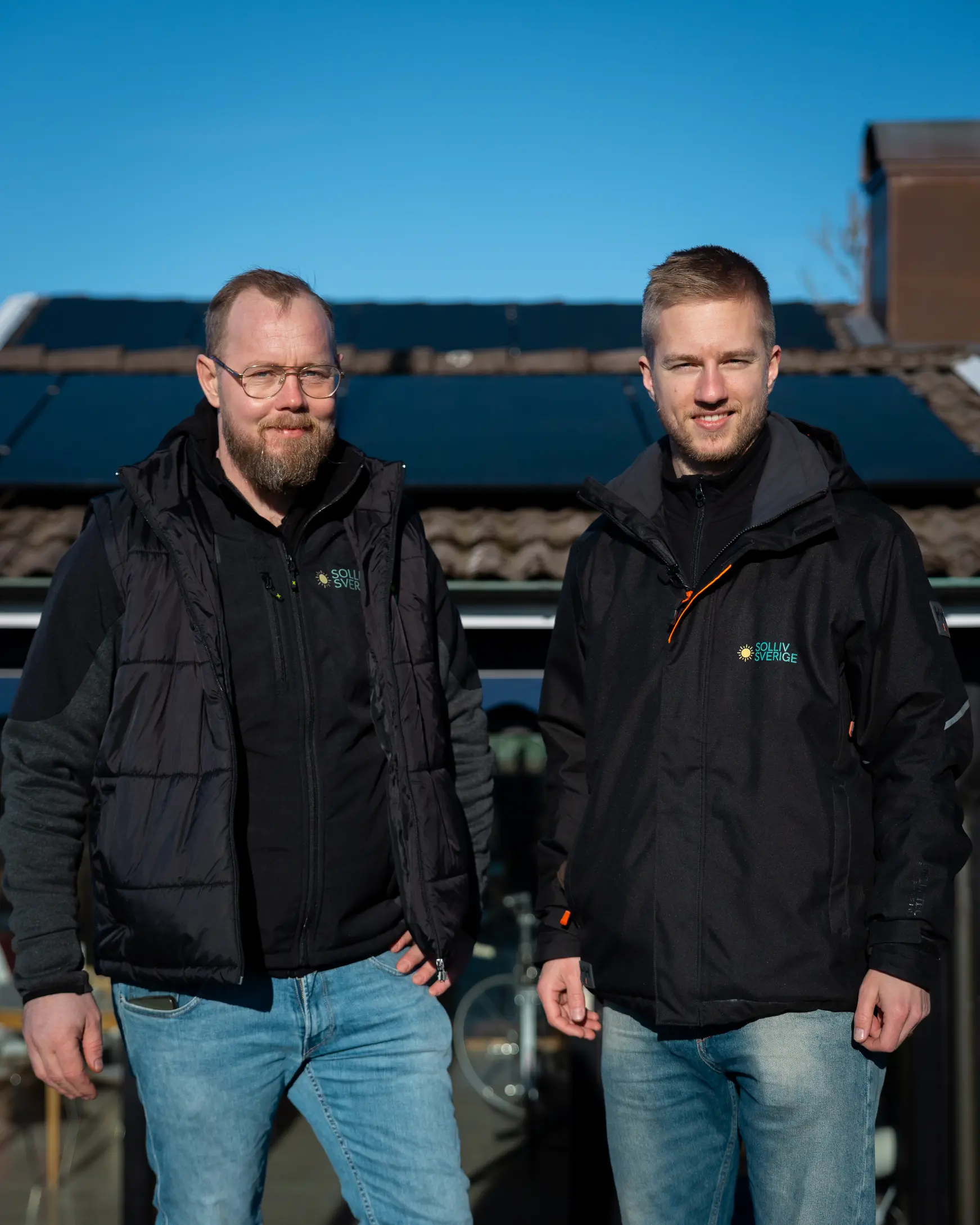 Johan Lundin och Simon Myrving från Solliv Sverige stående utomhus framför ett tak med solceller.